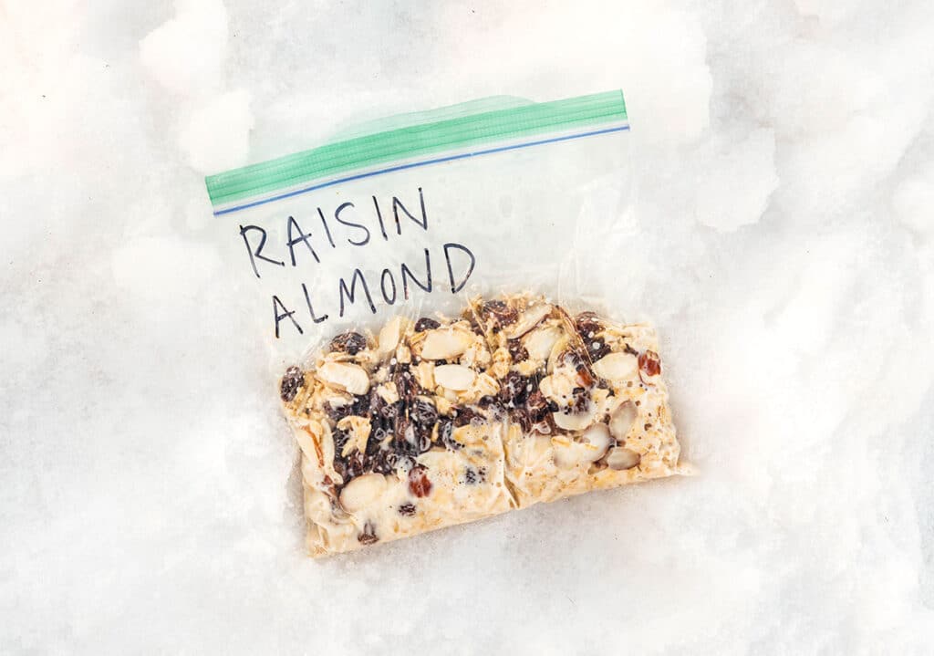 An on-the-go oatmeal pouch filled with rolled oats, milk, raisins, and shredded coconut