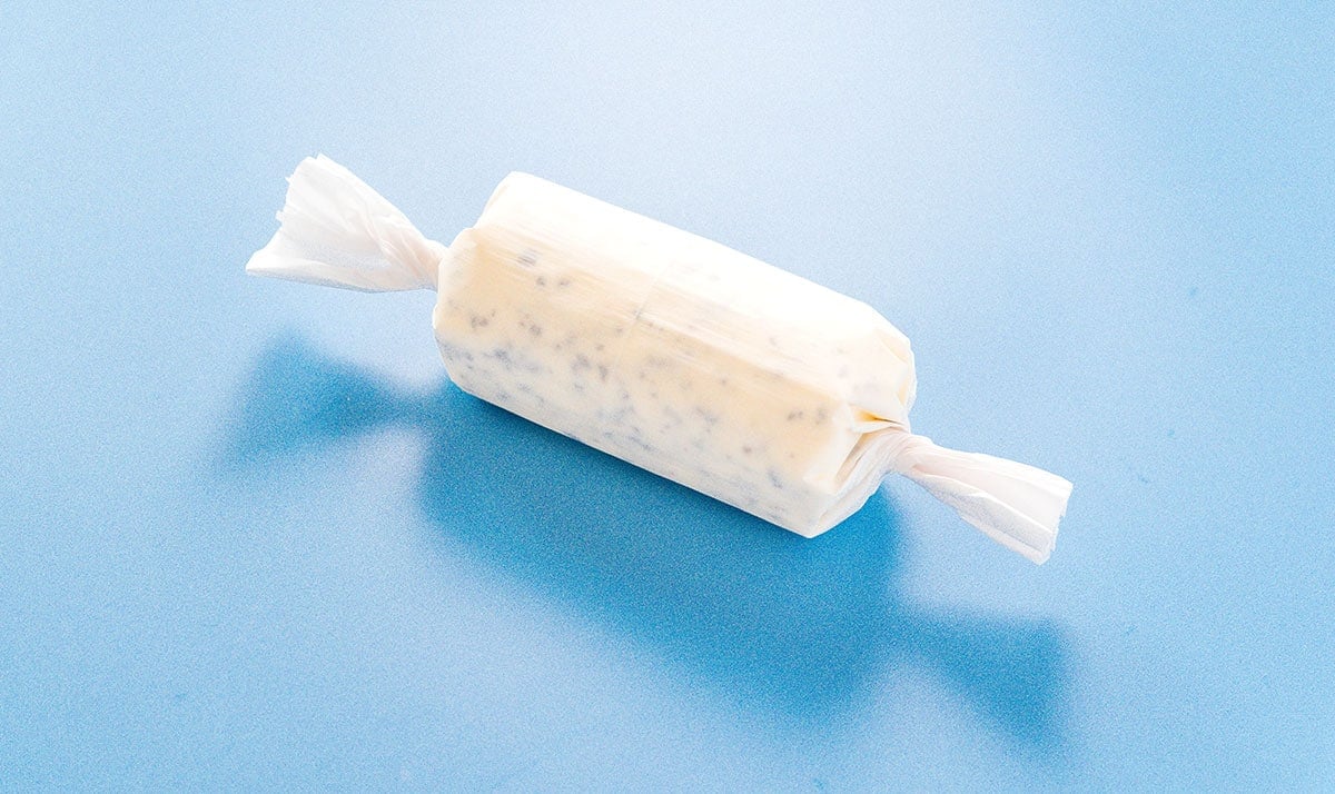 A log of truffle butter rolled up in a piece of parchment paper