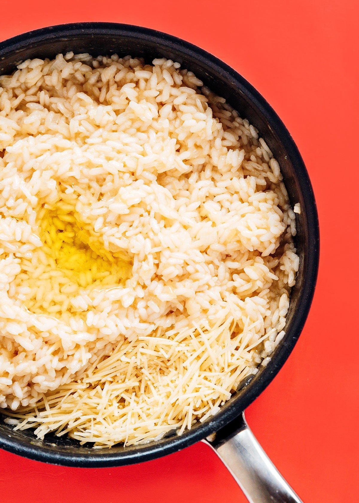 A pan filled with cooked arborio rice, parmesan cheese, and truffle oil