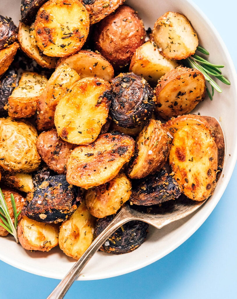 A white bowl filled with garlic and rosemary potatoes