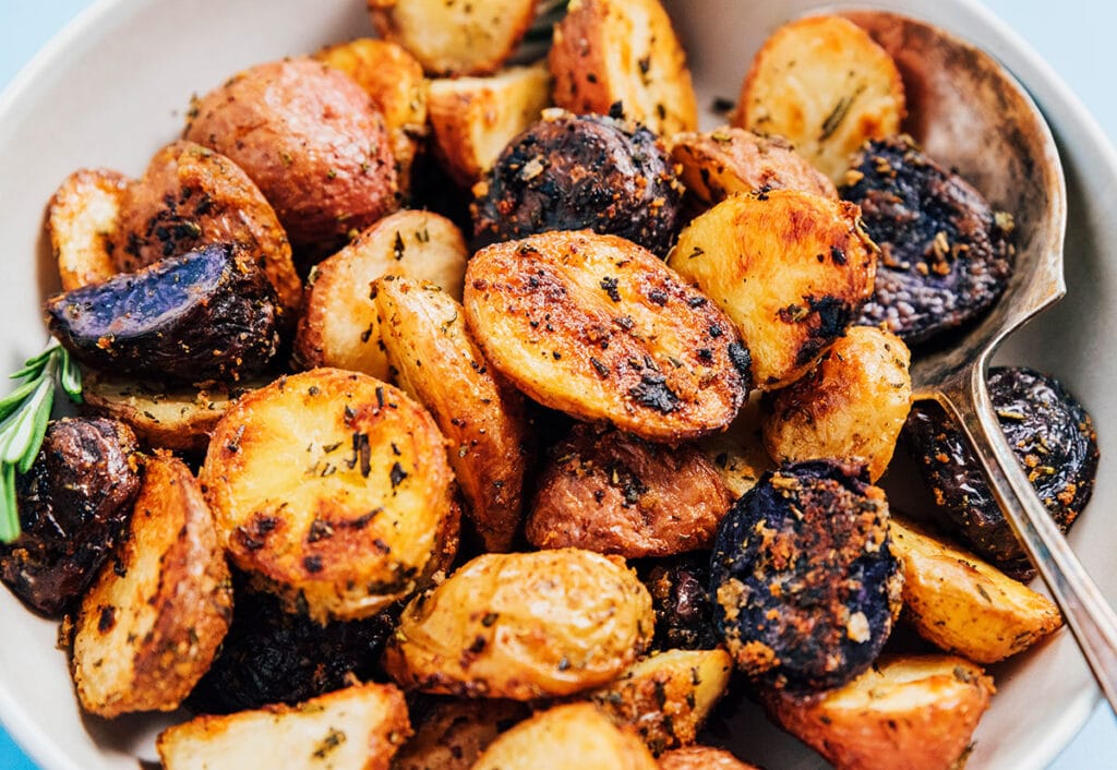 An up-close view of roasted rosemary potatoes inside a white bowl