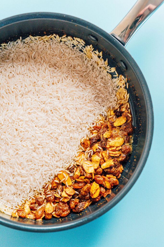 A skillet filled with flavorings and basmati rice