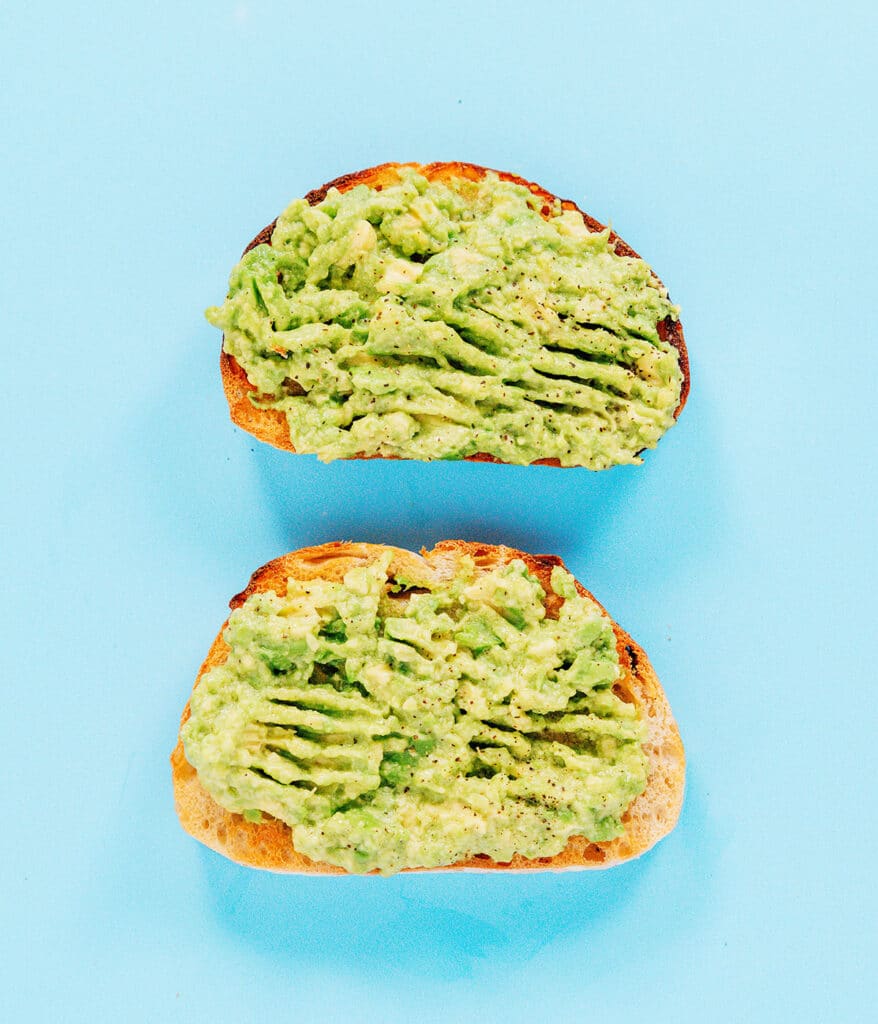 The classic toast with two pieces of toast topped with mashed avocado and lemon juice.