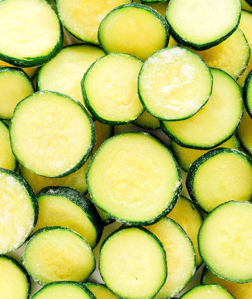 Close up of zucchini rounds that have bits of ice on them.