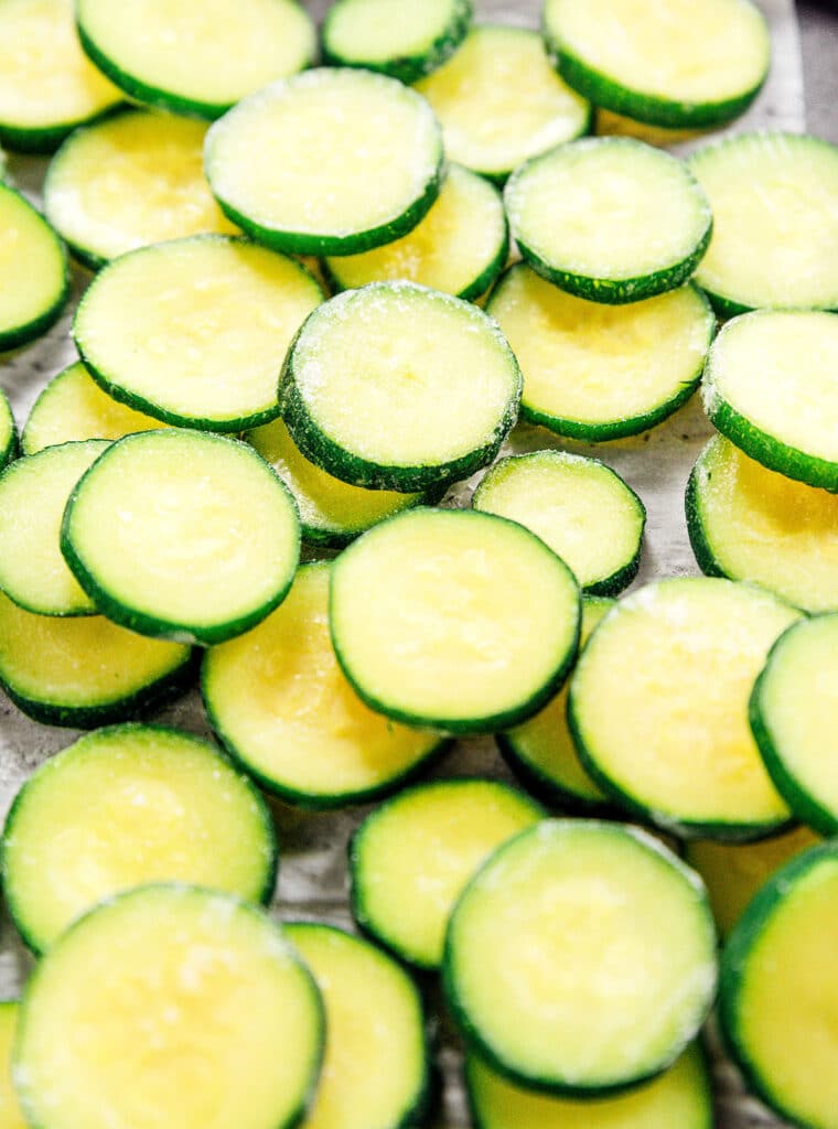 Close up of icy zucchini rounds on a baking sheet.