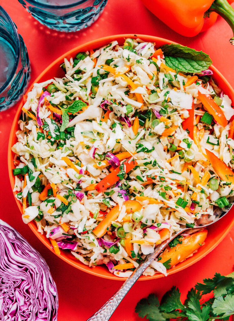 A red bowl filled with Thai cabbage salad