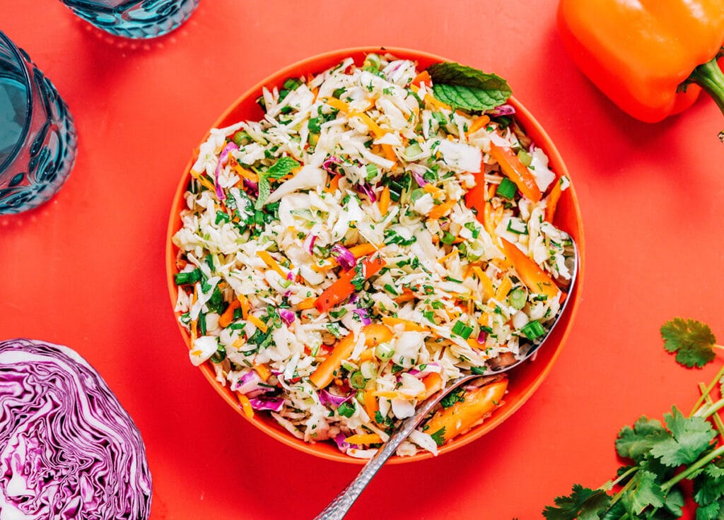 A red bowl filled with Thai cabbage salad