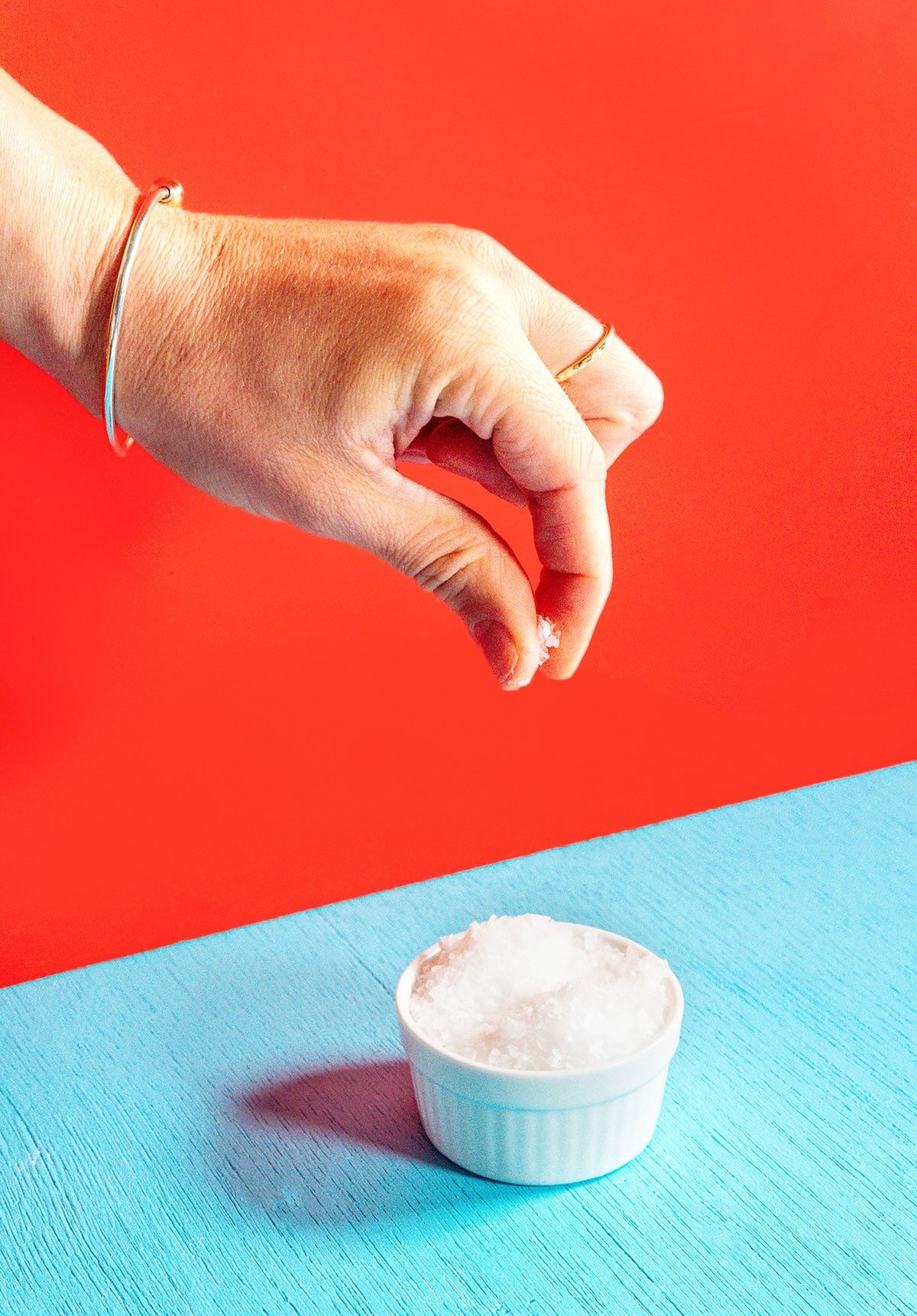A photo of a hand holding a pinch of salt