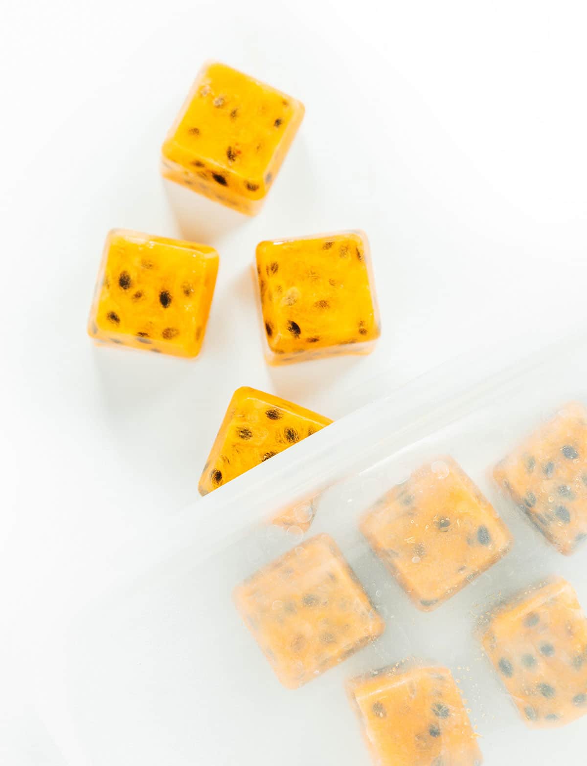 Frozen passion fruit cubes being poured out of a Ziploc bag.