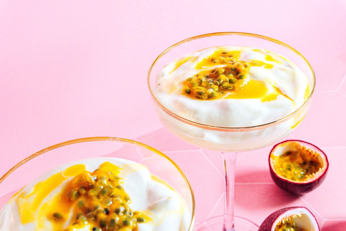 Closeup of passion fruit mousse in two martini glasses.