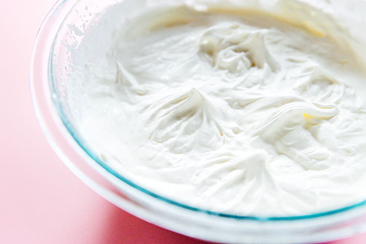 A mixing bowl of whipping cream that has been whipped into stiff peaks.