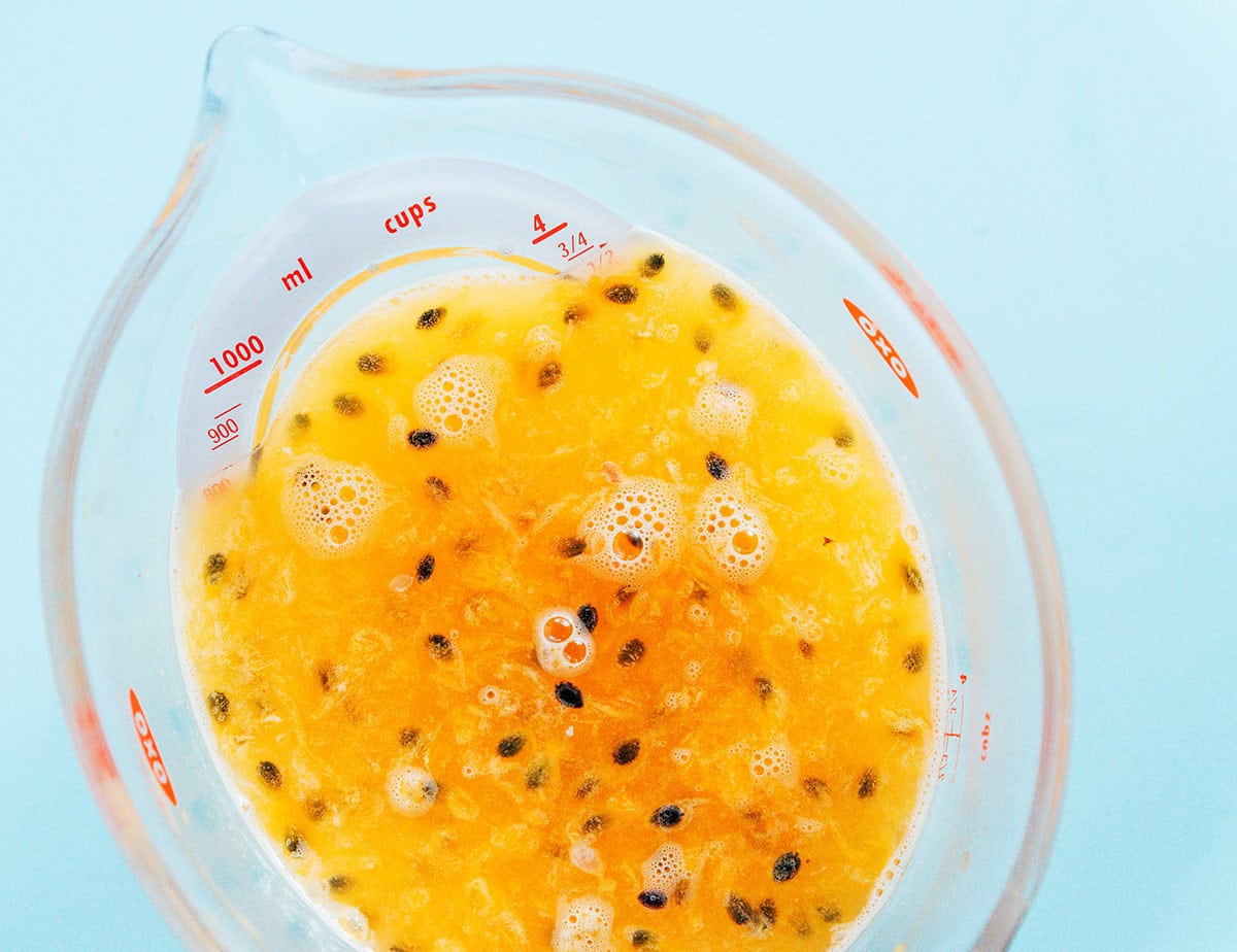 Passion fruit puree with some pulp mixed in in a spouted container.