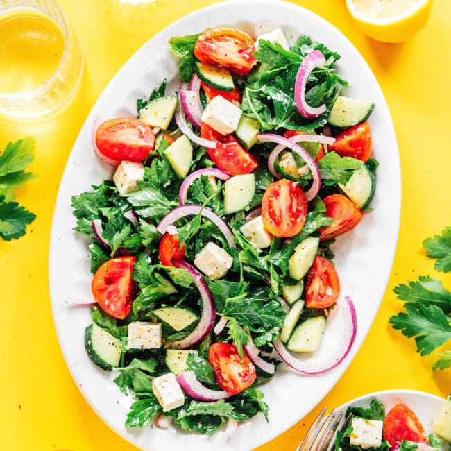Parsley salad with tomatoes and cucumber on a white platter