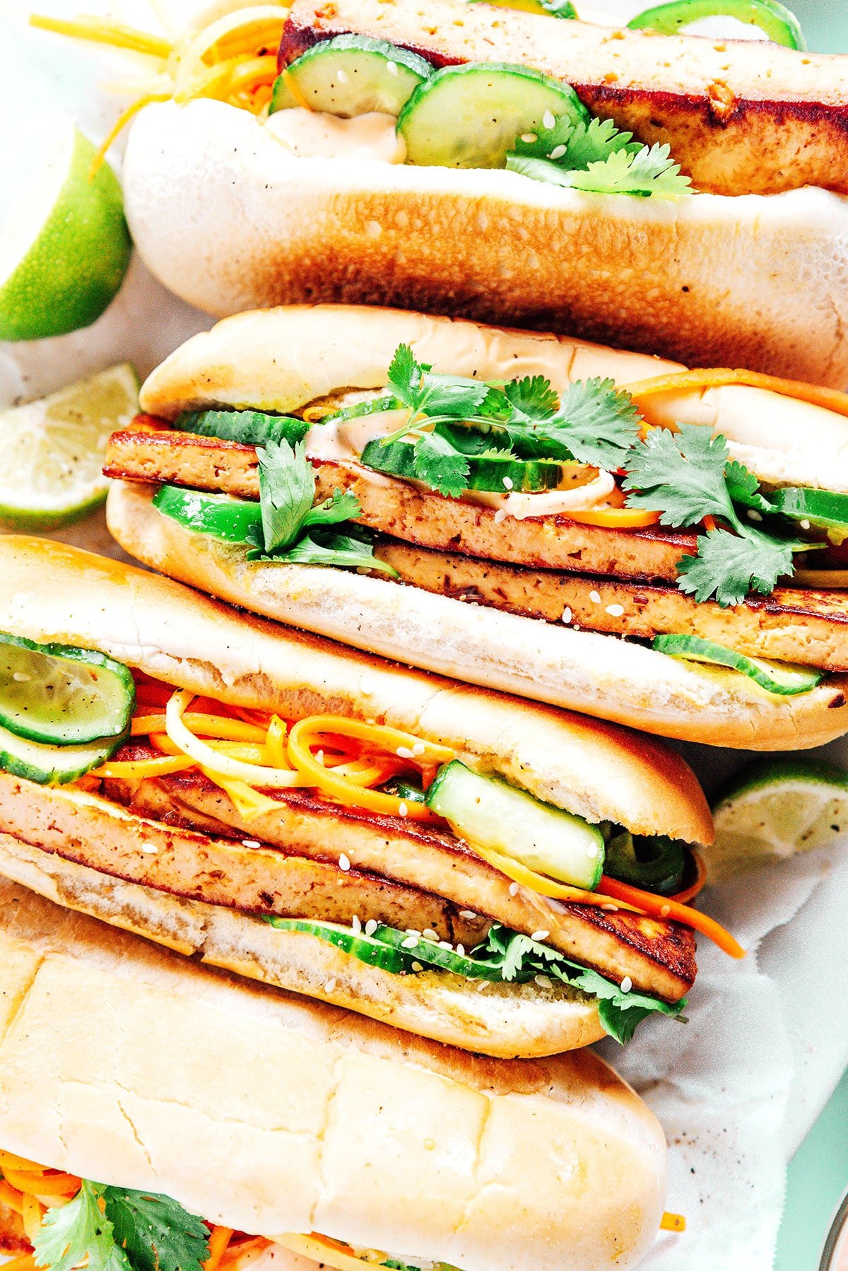 A platter filled with 4 tofu banh mi sandwiches in row.