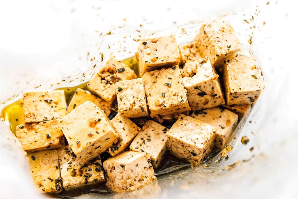 Tofu cubes and balsamic herb marinade in a zippered bag.