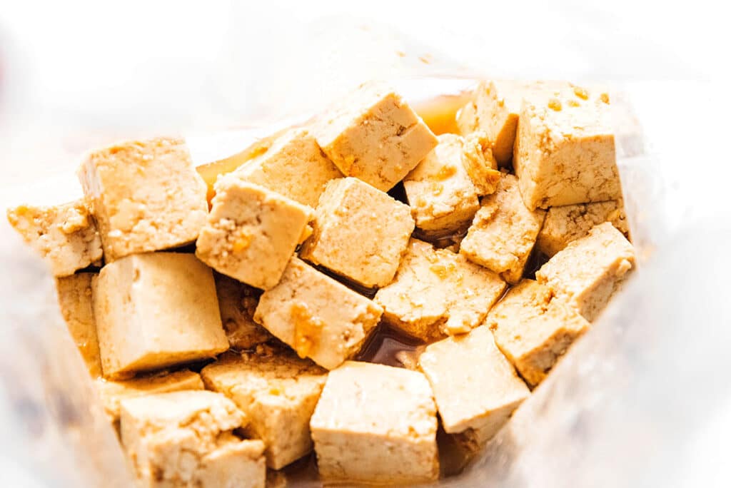 Tofu cubes in a bag full of sesame ginger marinade.