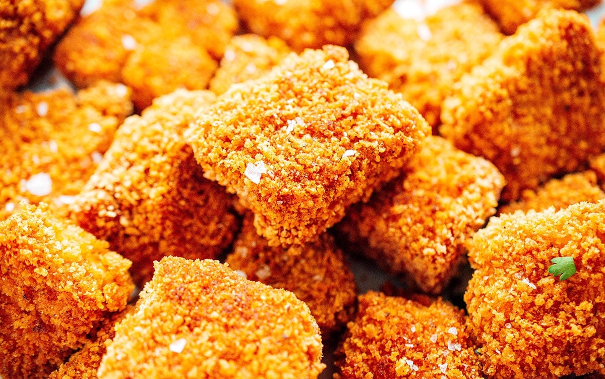 Close up of the texture of breaded tofu nuggets in a pile.