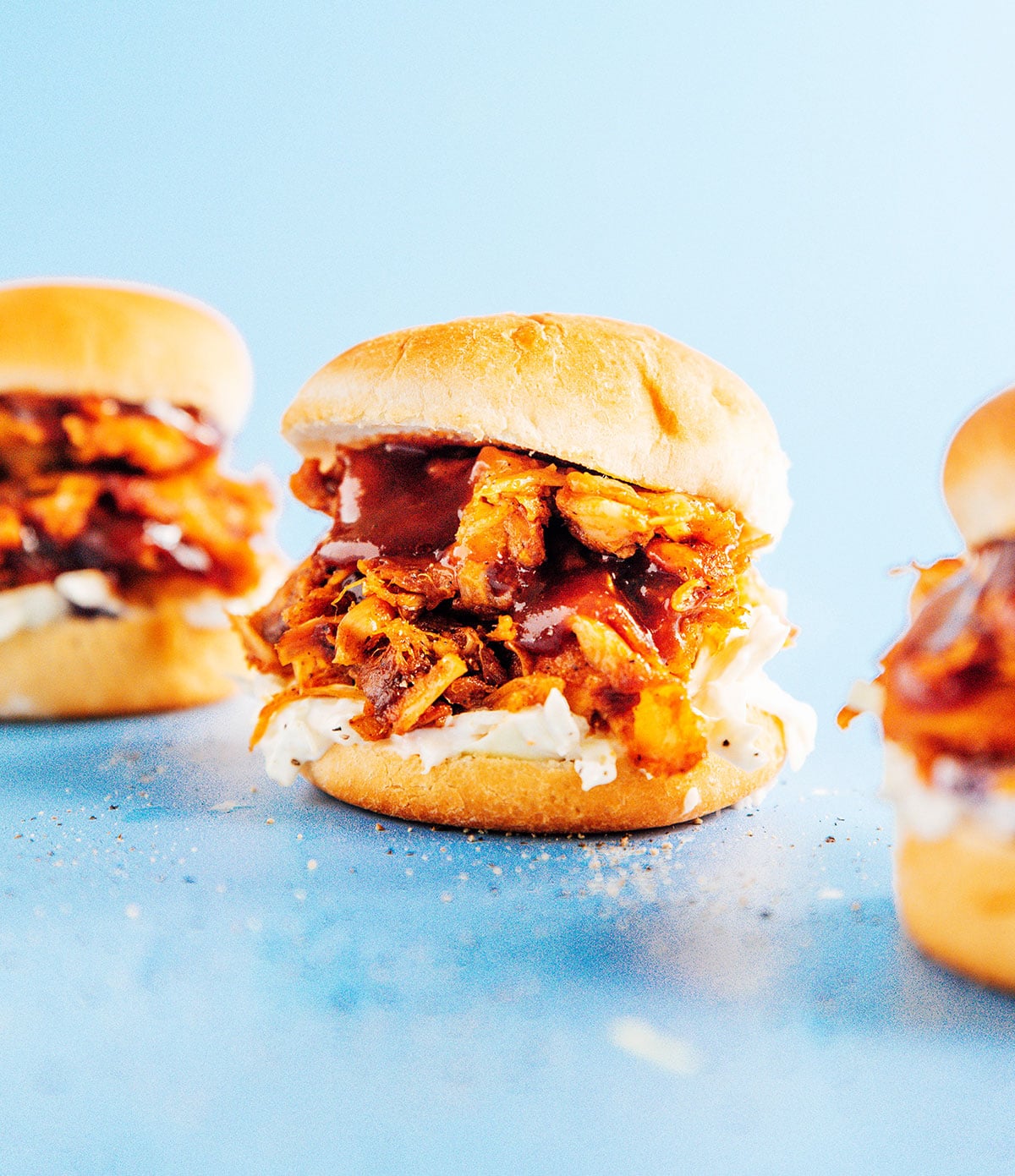 Up close image of bbq jackfruit slider with coleslaw and dripped bbq sauce.