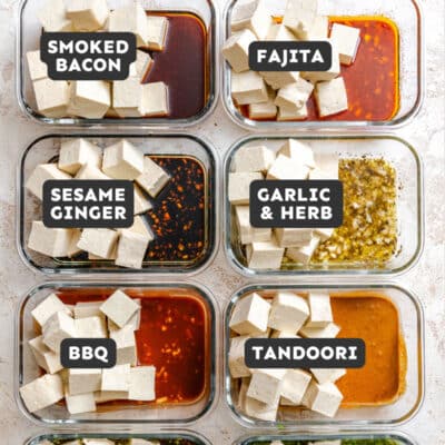 Eight glass containers of tofu, each marinating in a unique sauce: smoked bacon, fajita, sesame ginger, garlic & herb, BBQ, tandoori, herby balsamic, and cilantro lime—perfect for exploring new tofu marinades.