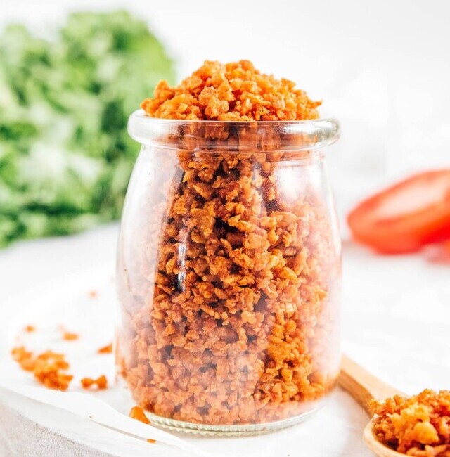 Vegan bacon bits in a glass jar on a white background