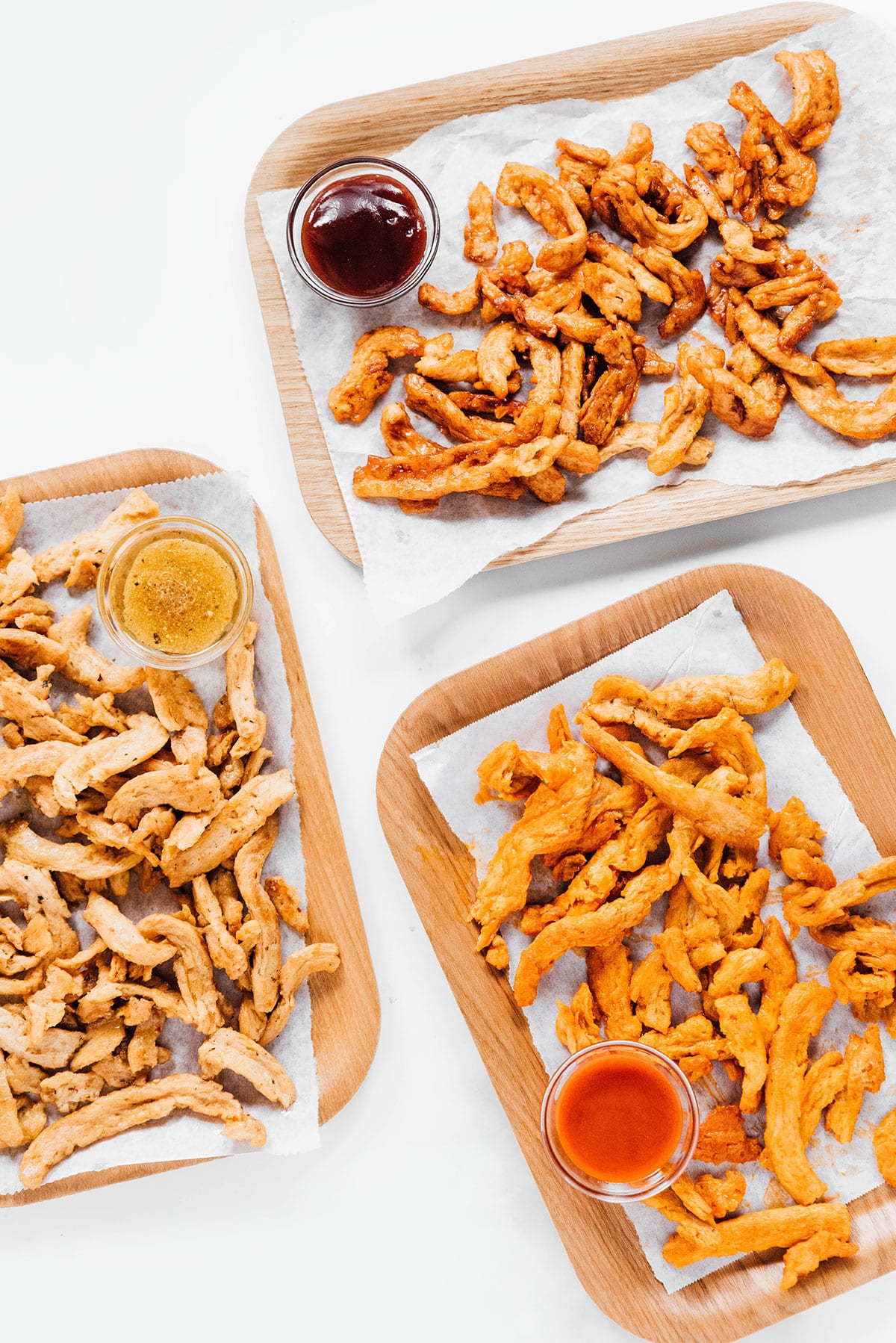 Three flavors of soy curls on rectangular plates.