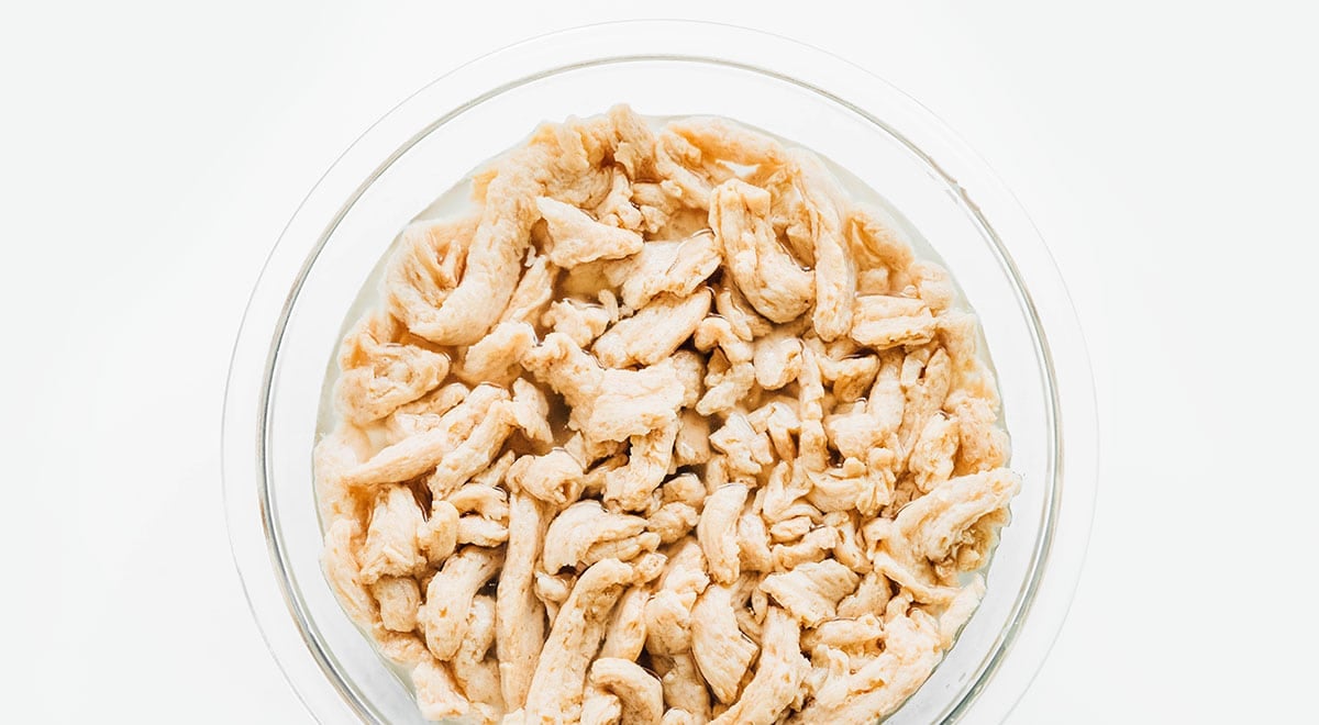 Soaking soy curls in glass bowl of water.