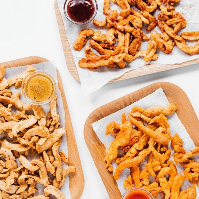 Three flavors of soy curls on rectangular plates.