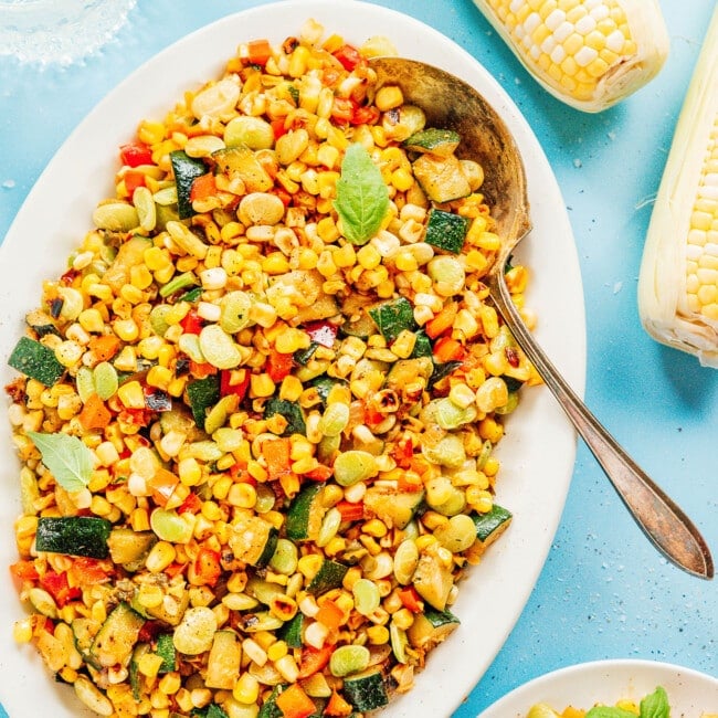 Succotash on a platter with a spoon