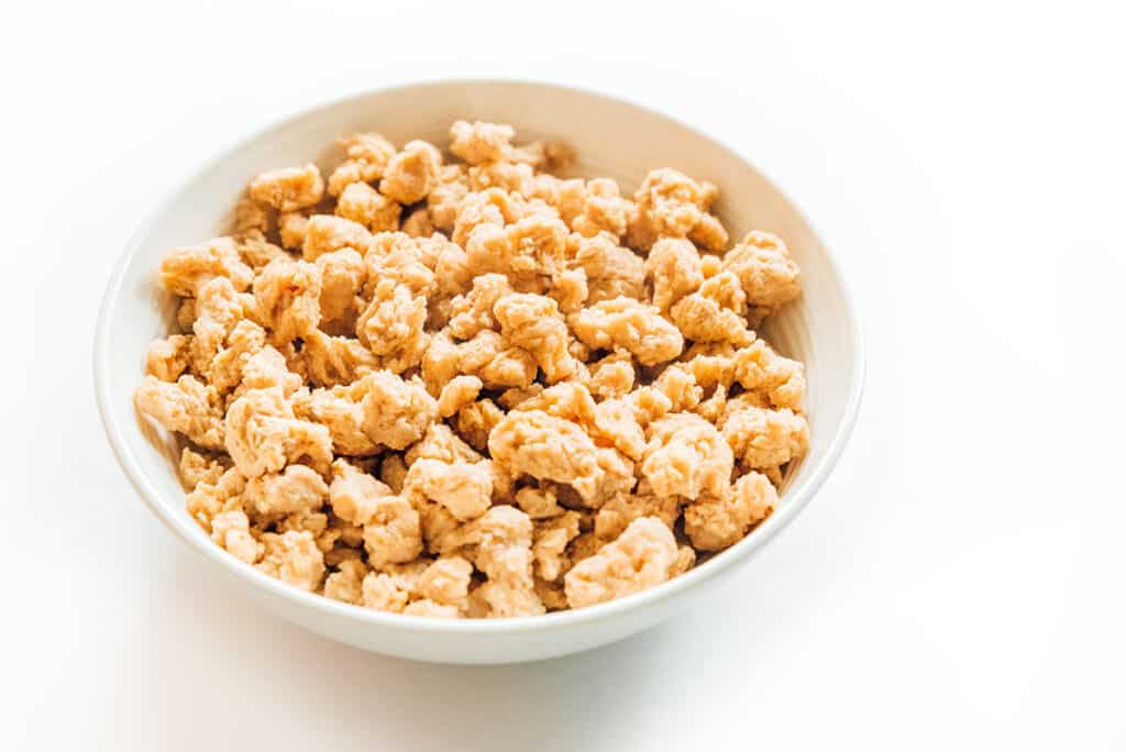 Textured vegetable protein crumbles in a white bowl.