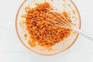 Whisking bacon bits in a glass bowl