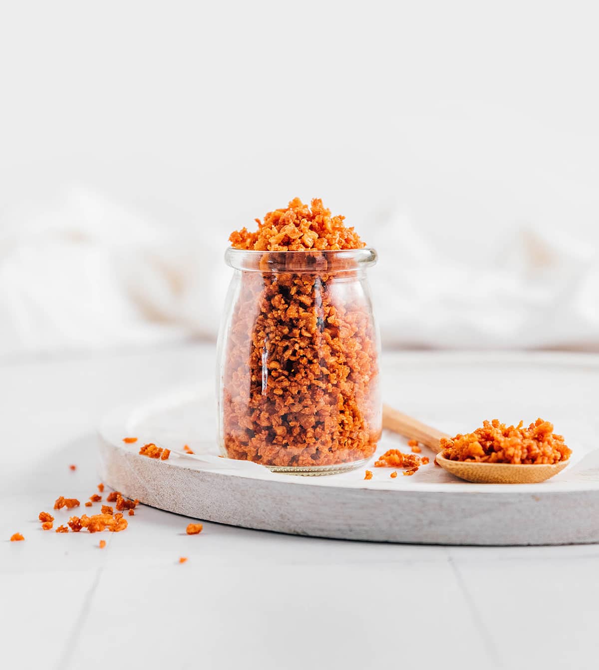 Vegan bacon bits in a glass jar on a white background