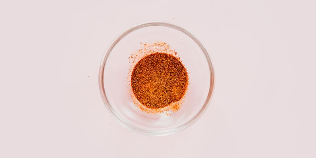 A small glass bowl with smoked paprika.