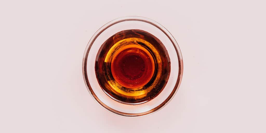 A small glass bowl with maple syrup.