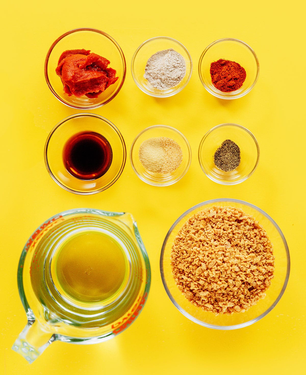 Ingredients to make vegan ground beef in small glass bowls on a yellow surface,