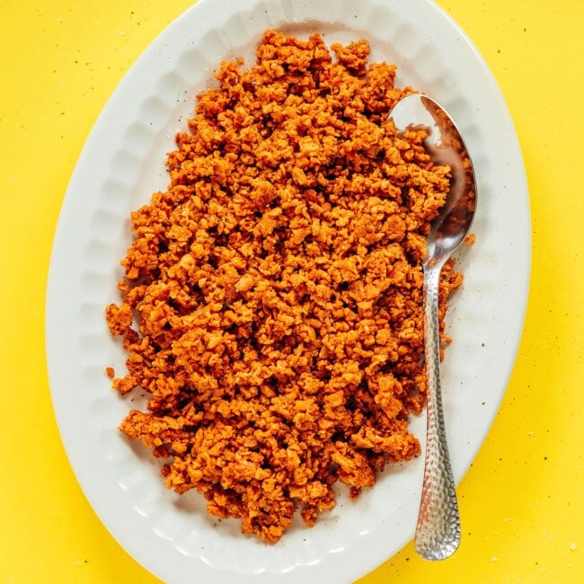 Vegan ground beef on a white platted with serving spoon