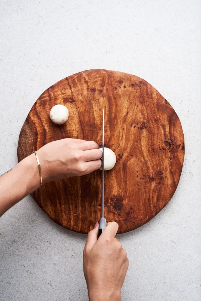Cutting a mushroom on a cutting board