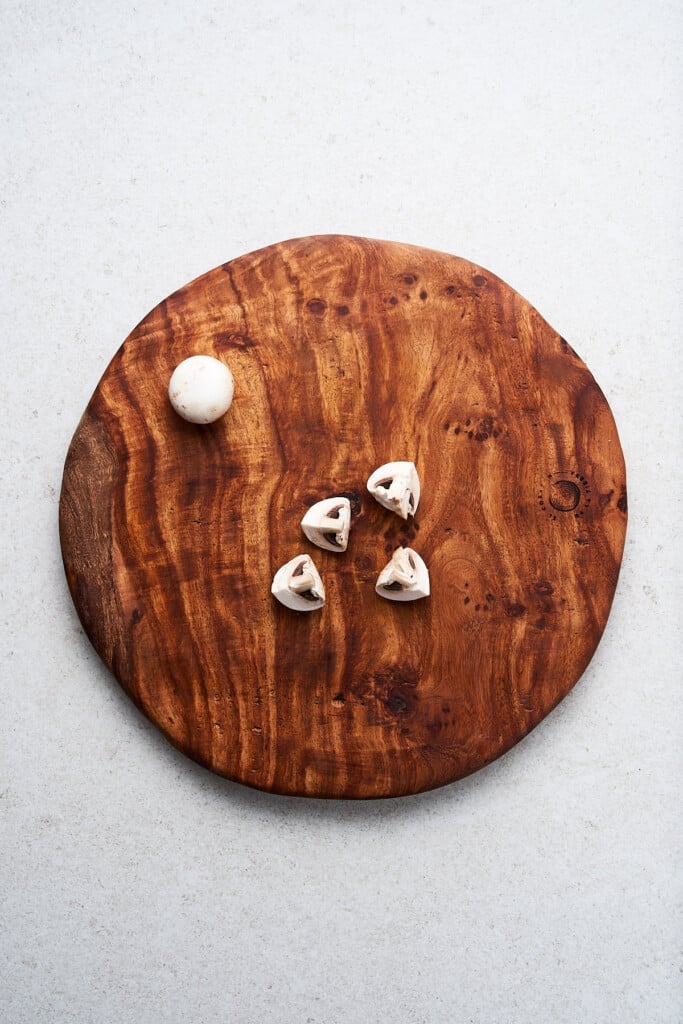 Quartering mushrooms on a cutting board