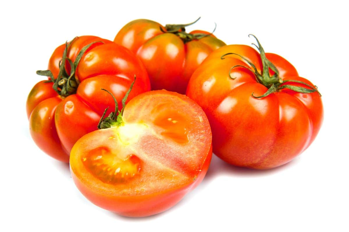 Four bucking bronco tomatoes on a white background.