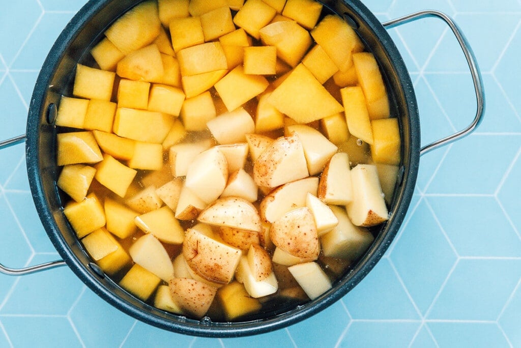 Diced potatoes and rutabaga in a pot of boiling water.