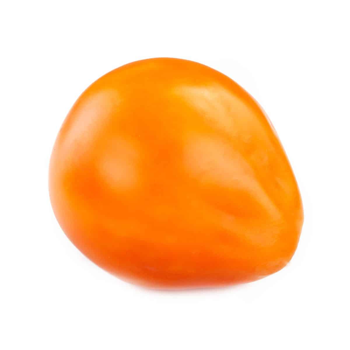 An orange oxheart tomato on a white background.