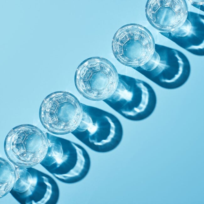 Clear shot glasses on a blue background