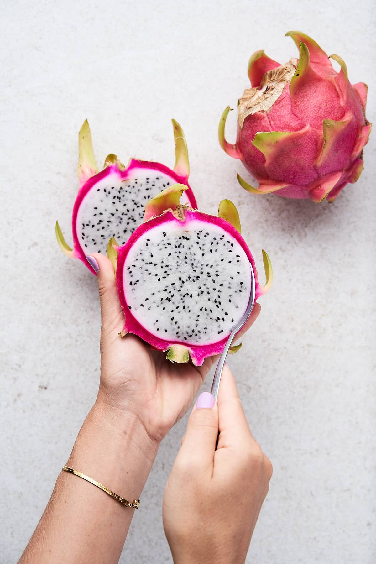 Scooping the flesh out of a dragonfruit