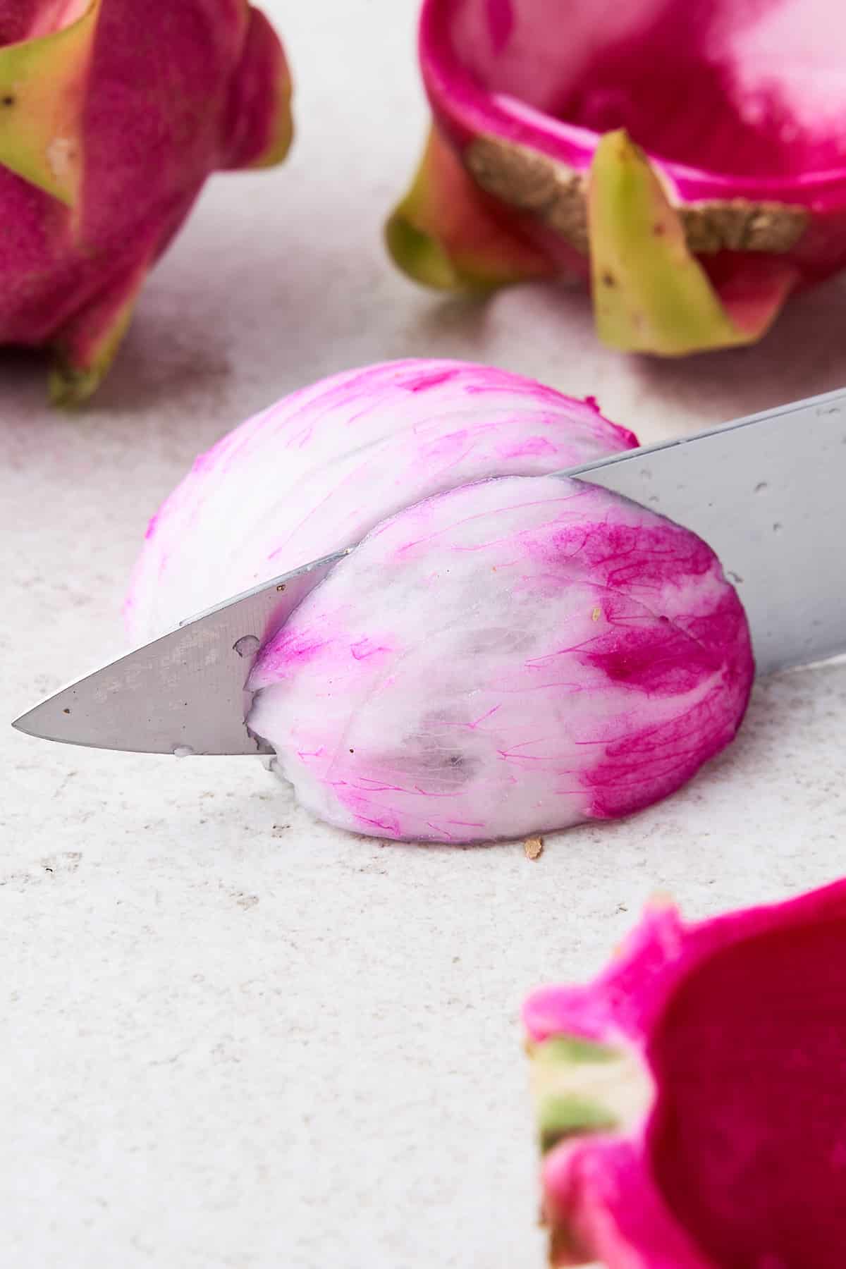 Knife slicing a dragonfruit
