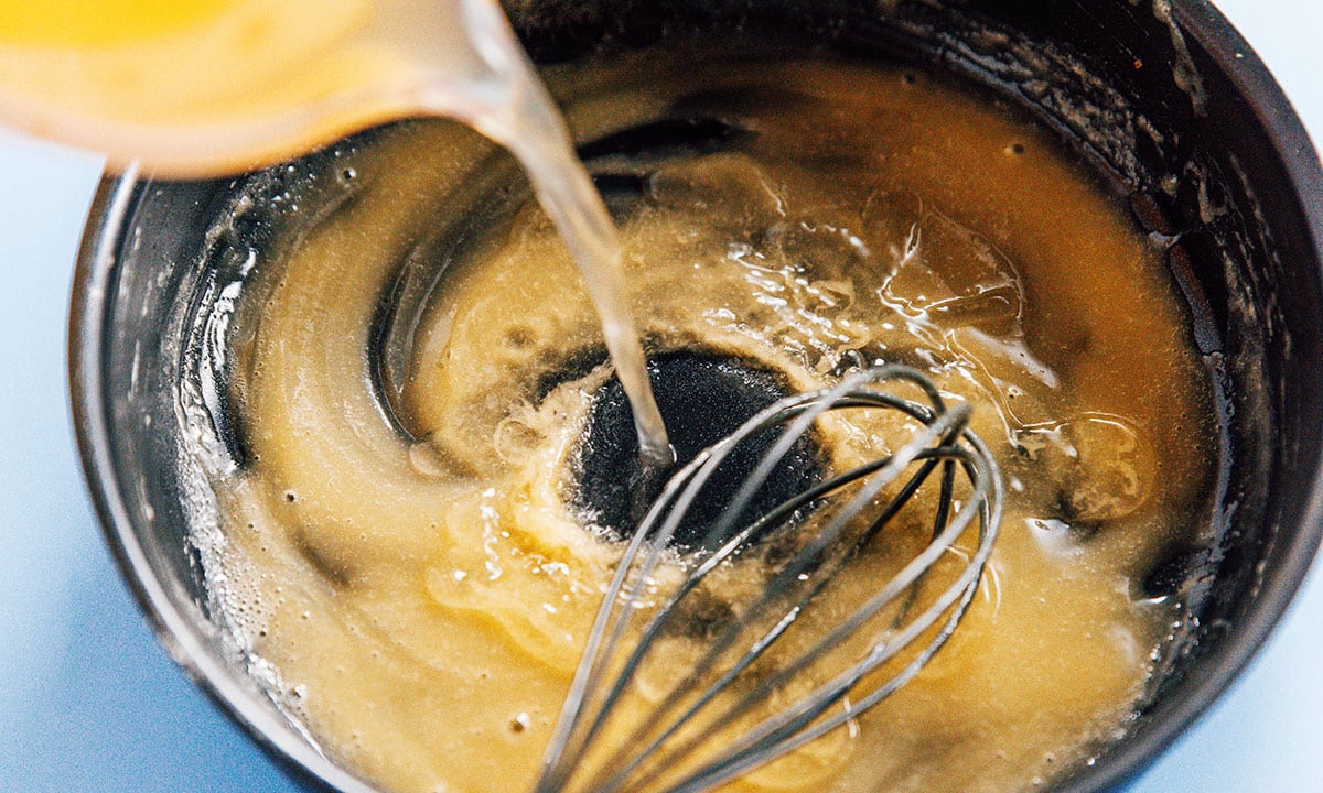 Liquid being added to gravy roux.