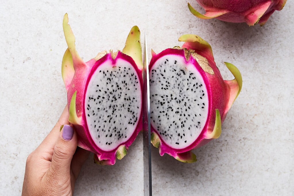 Halve: Place dragon fruit down on a flat surface. Using a sharp chef’s knife, slice it in half lengthwise.