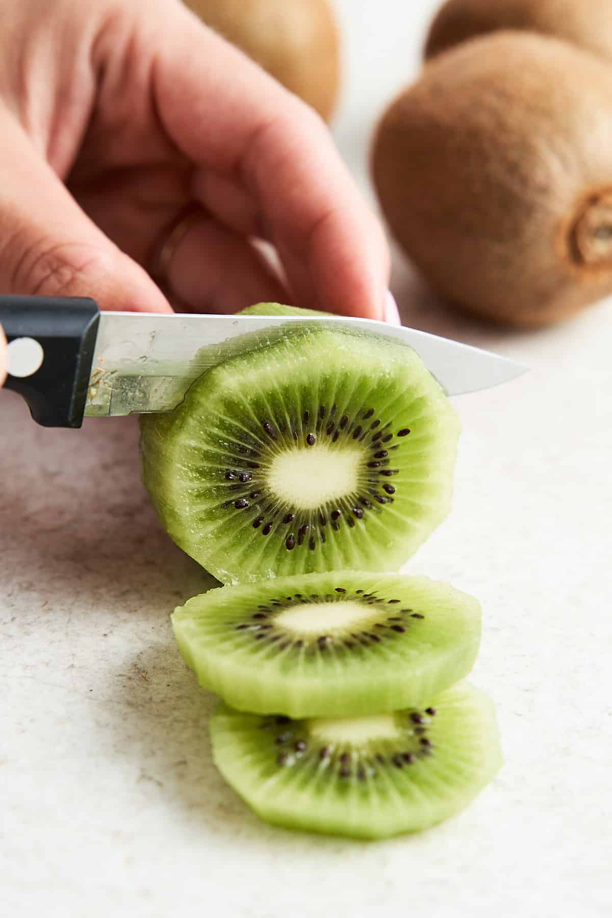 Slicing a kiwi into rounds.