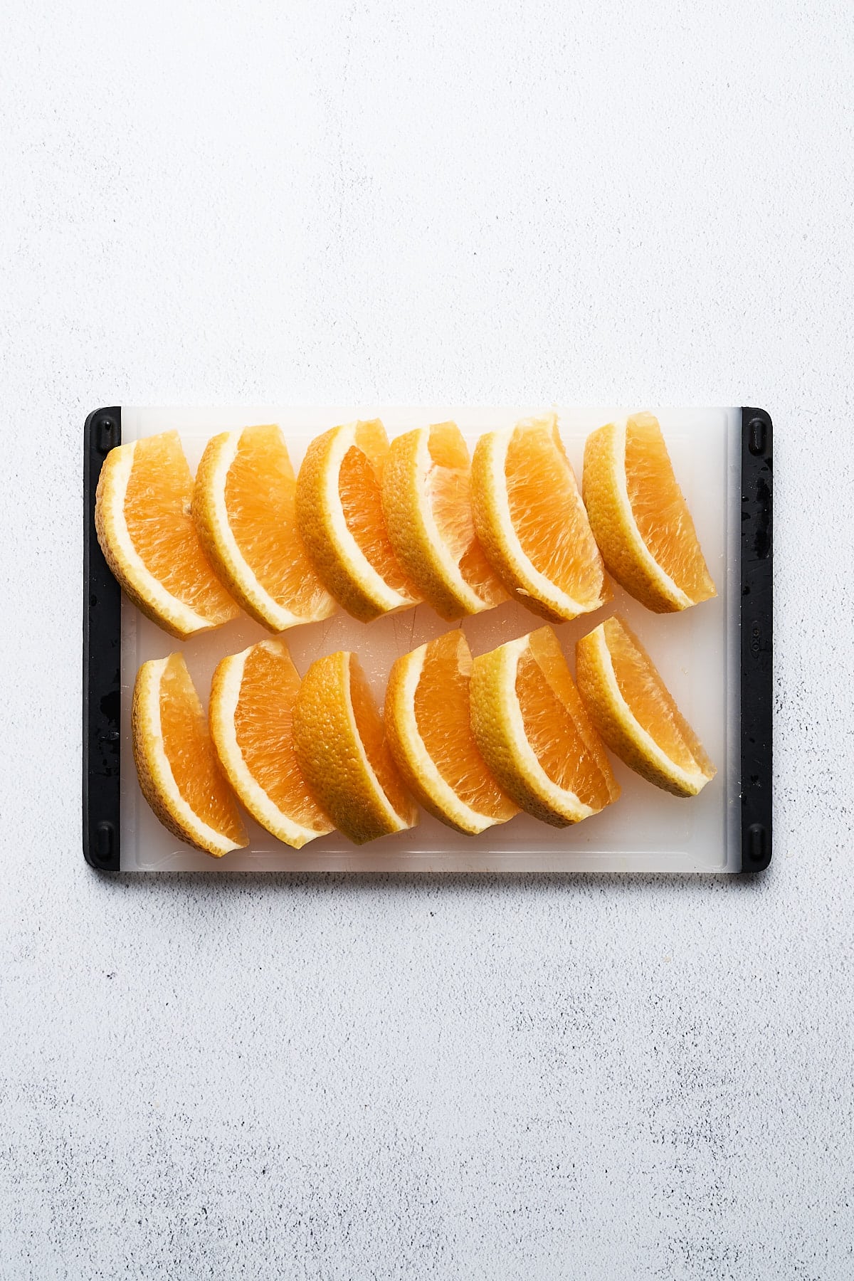 Orange wedges on a cutting board.