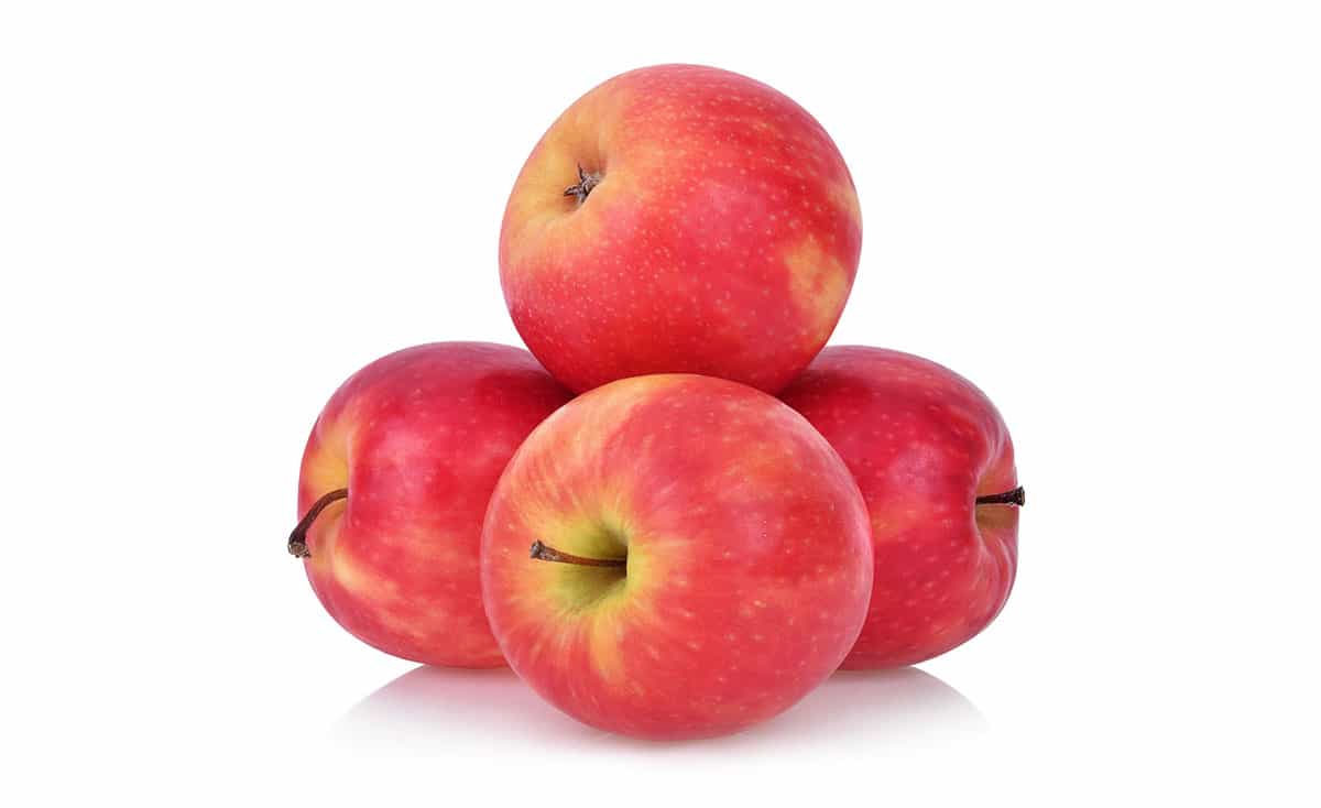 Pink lady apples on white background.