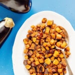Air fryer eggplant on a white platter with a spoon.