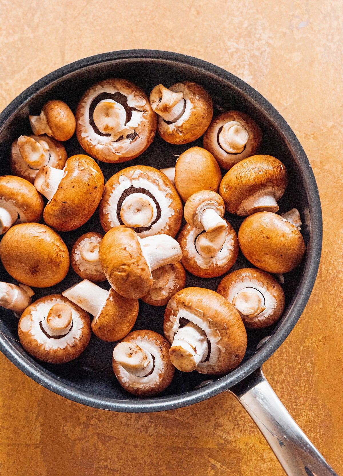 Baby Bella mushrooms in a saucepan.
